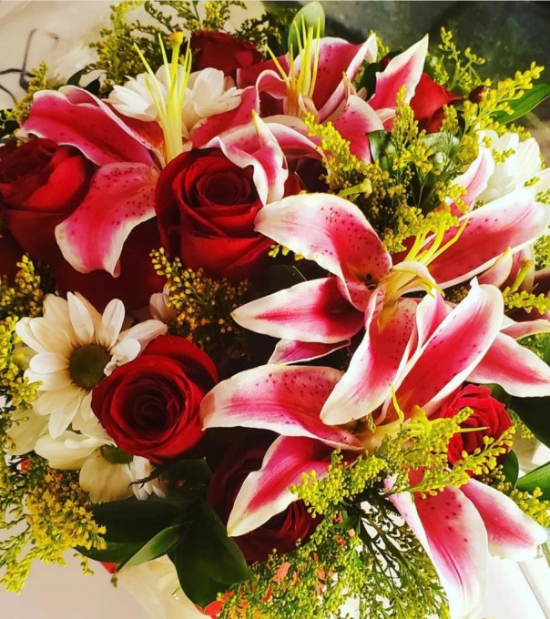 lìrios e rosas vermelhas folhagem  tango e ruscus.