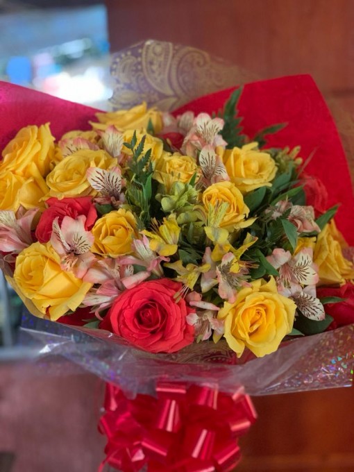 12 rosas amarelas com astromelhas claras,embalado em papel poli , decorado com laço de fita. 
