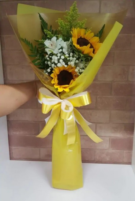 Buque estilo ramalhete com 2 girassois e folhagens e embalagem clean.